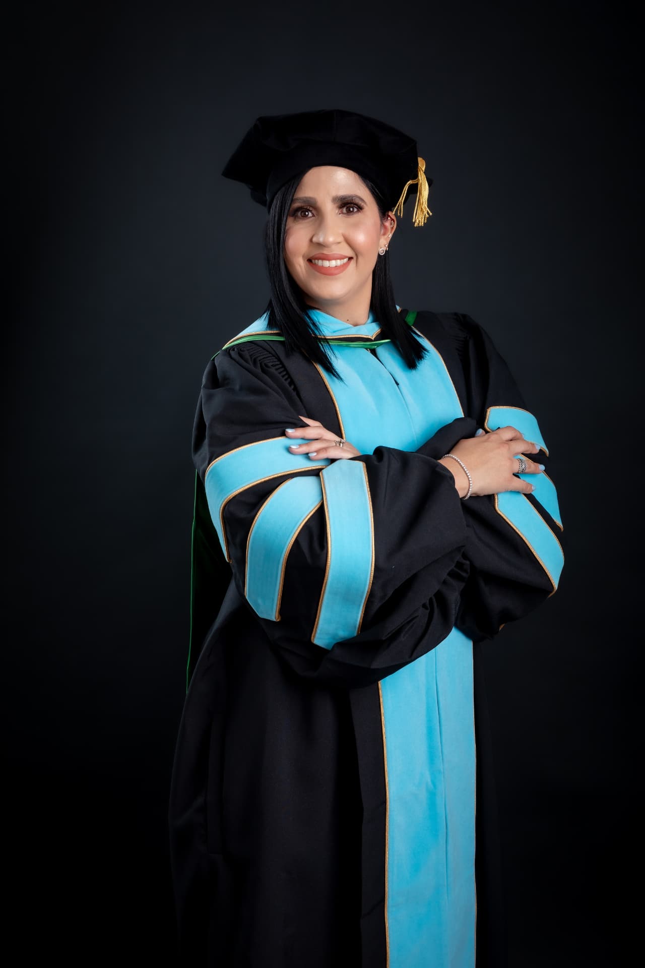 Graduanda con toga doctoral negra y azul sobre fondo oscuro