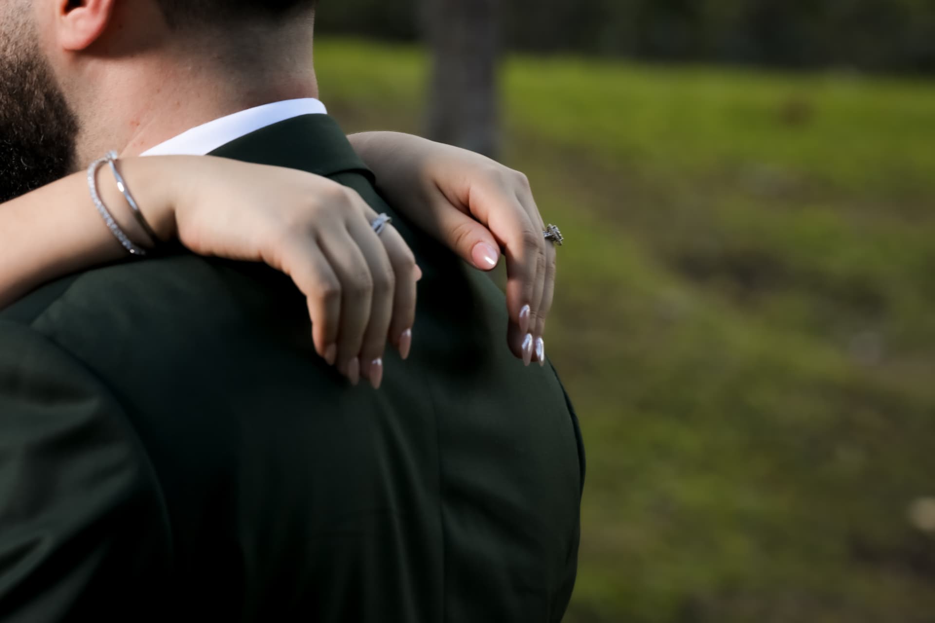 Detalle de manos de novios con anillos y brazos abrazados