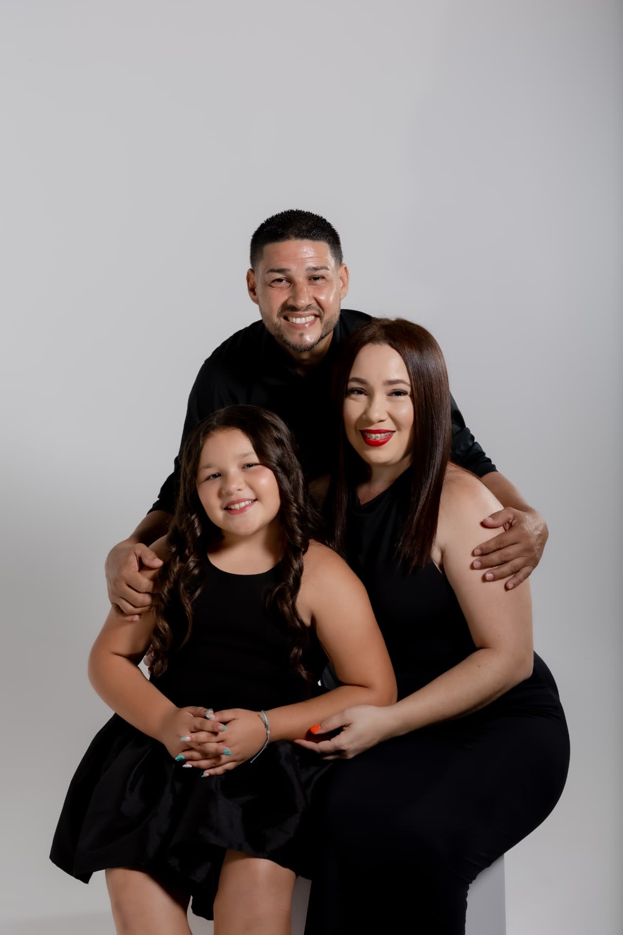 Familia sonriente con vestimenta negra en sesión de studio