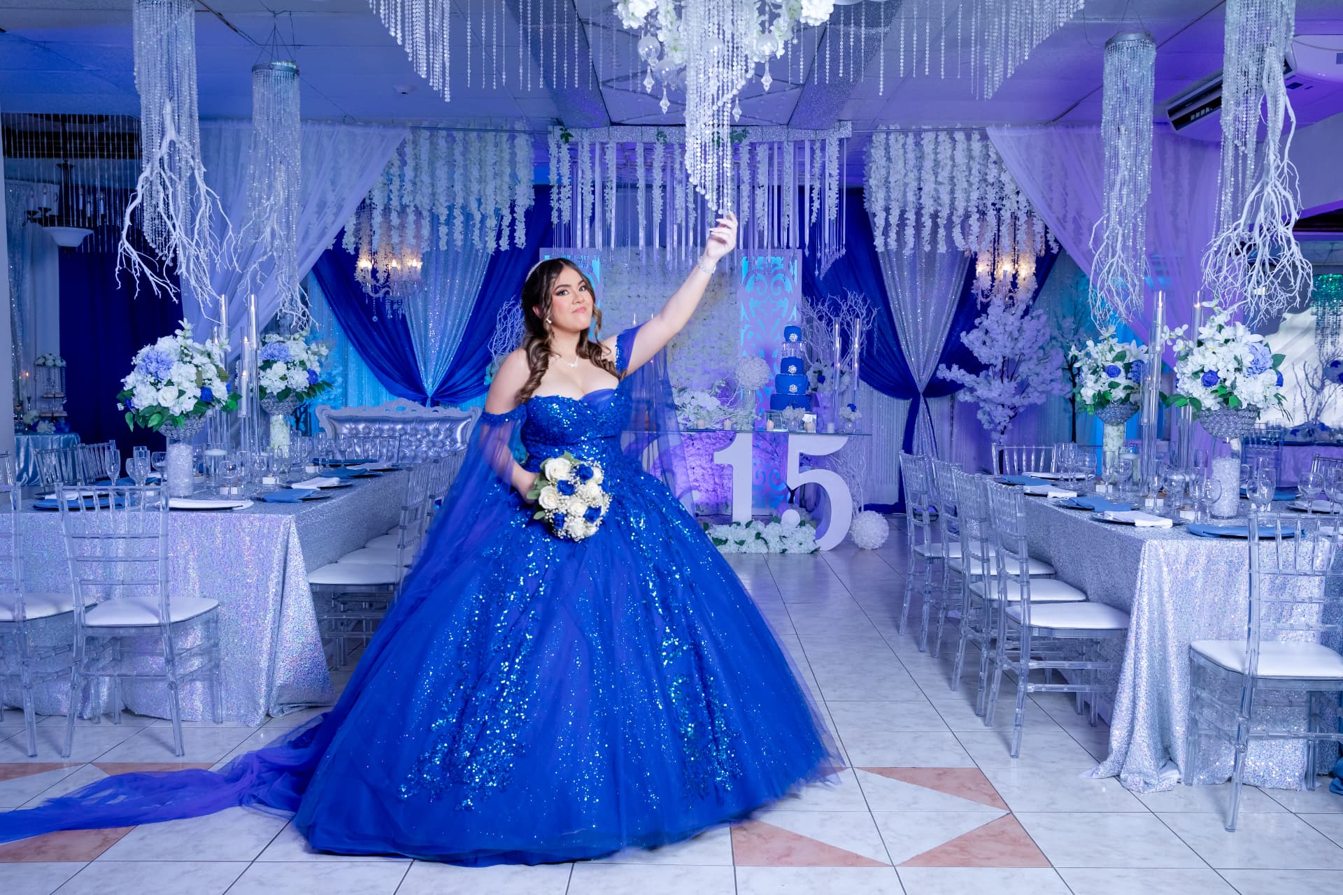 Quinceañera con vestido azul en salón decorado para su celebración