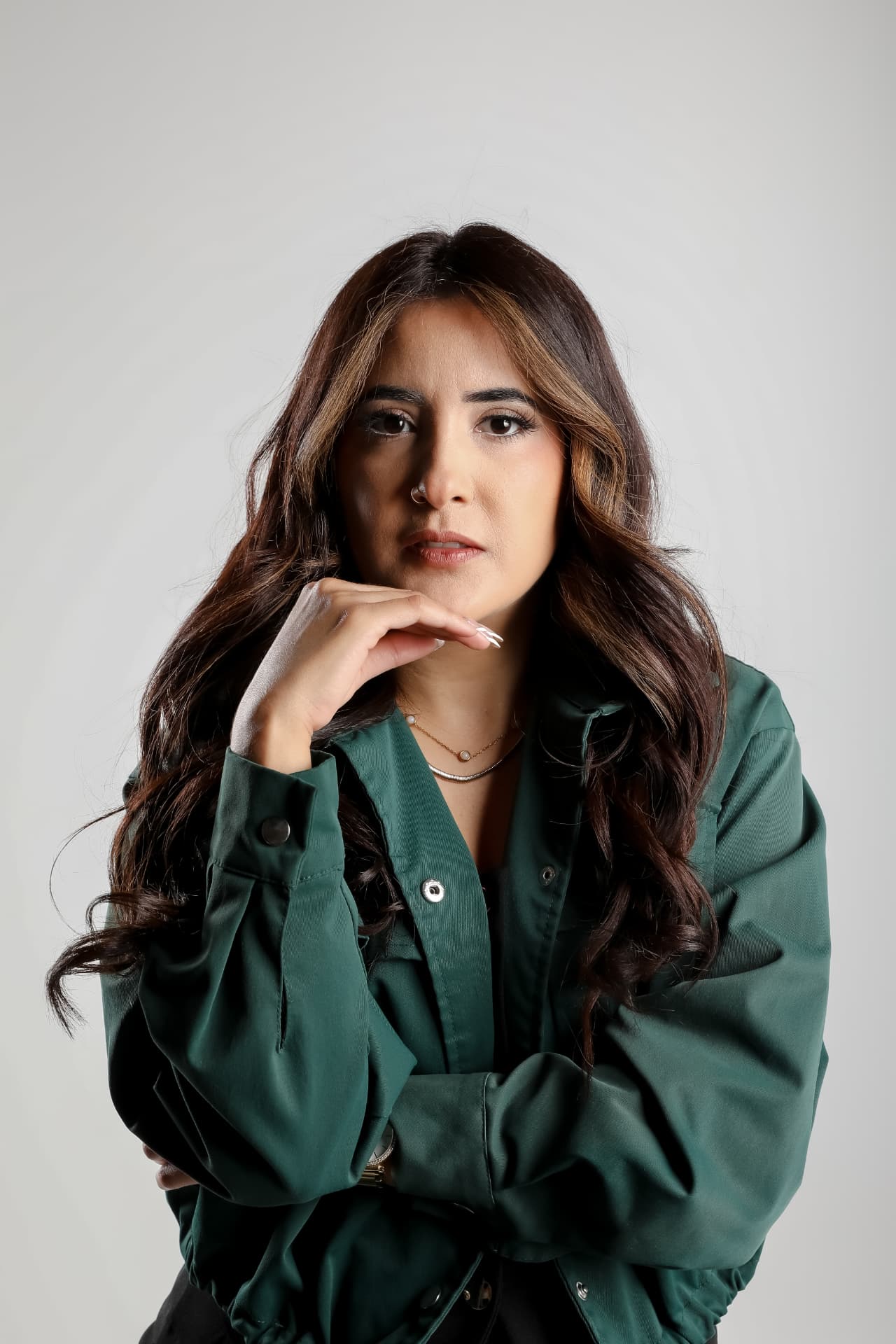 Retrato de mujer con camisa verde sobre fondo gris